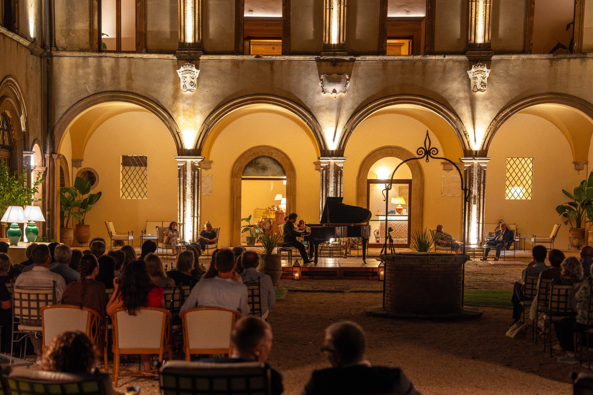 Il concerto nel cortile di Volte Alte: il pubblico di spalle e il cortile illuminato