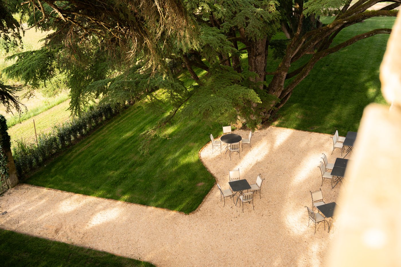 La terrazza in ghiaia e il parco di Volte Alte visti da una finestra del primo piano